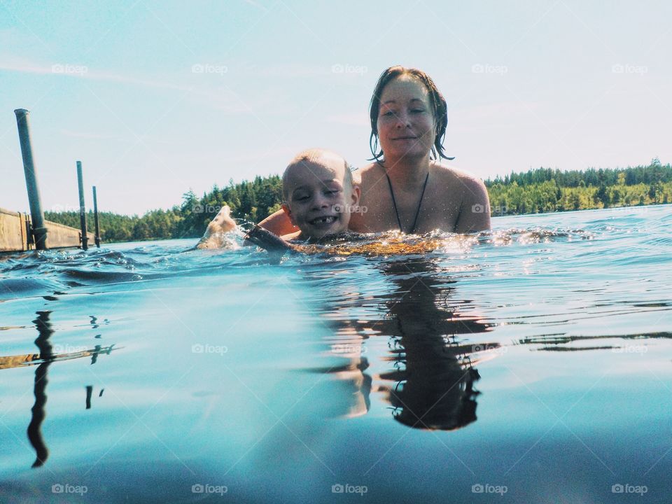 Mother and her son playing in the lake