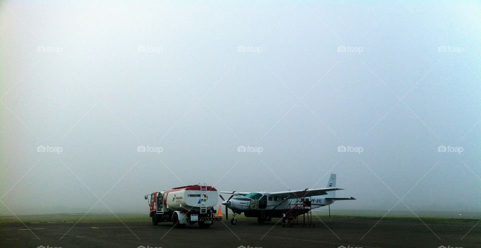 Cessna Caravan being refuelled in foggy weather