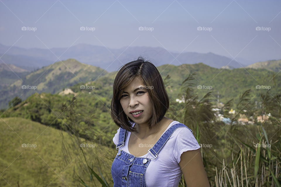 Portrait of Asean Woman The background of mountains and sky  at Nern Chang Suek  hills, Kanchanaburi, Thailand