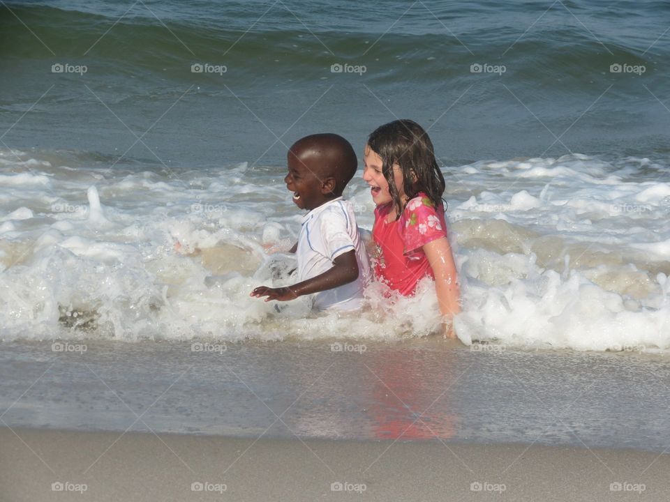children splashing in the ocean