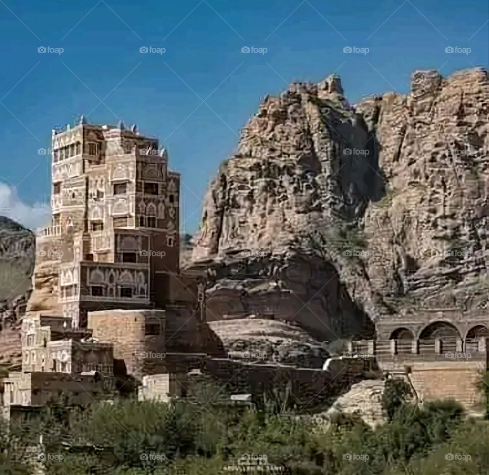 The image embodies a natural natural plate of the mountains of nature, where green agricultural stands are graded on the slopes as if they were lines of a poem, which fog harmoniously wrapped, and clouds hugged them in the mountain knife and the whis