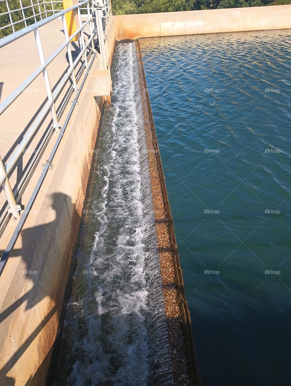 cool photo of water treatment plant where water flow is going through end of a basin