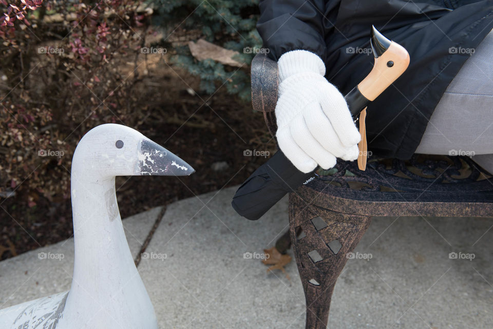 Close-up of a person's hand holding a duck head handle umbrella