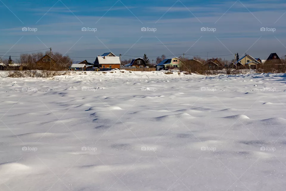 Houses against the backdrop of a frozen river.