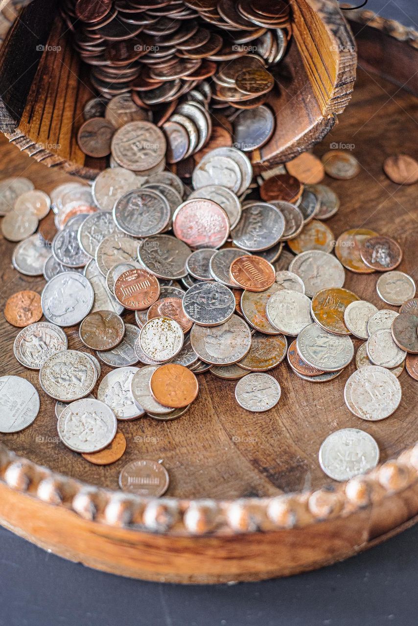 Coins on wooden tray