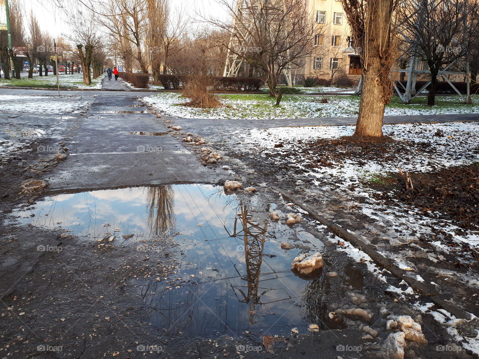 Electric tower reflects on the puddle