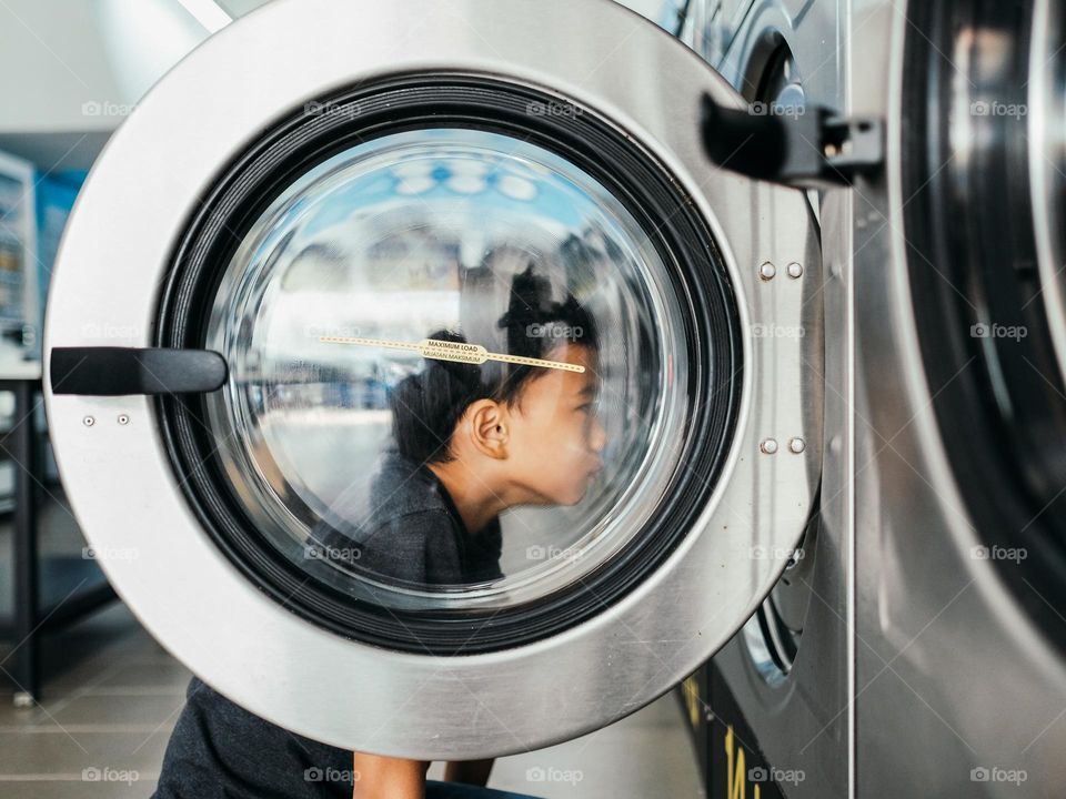 A boy looking into a washing machine