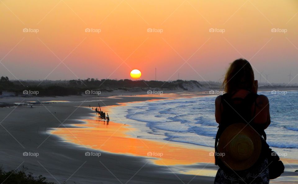 A photographer at the sunset. A photographer taking picture of the sunset at a Brazilian beach