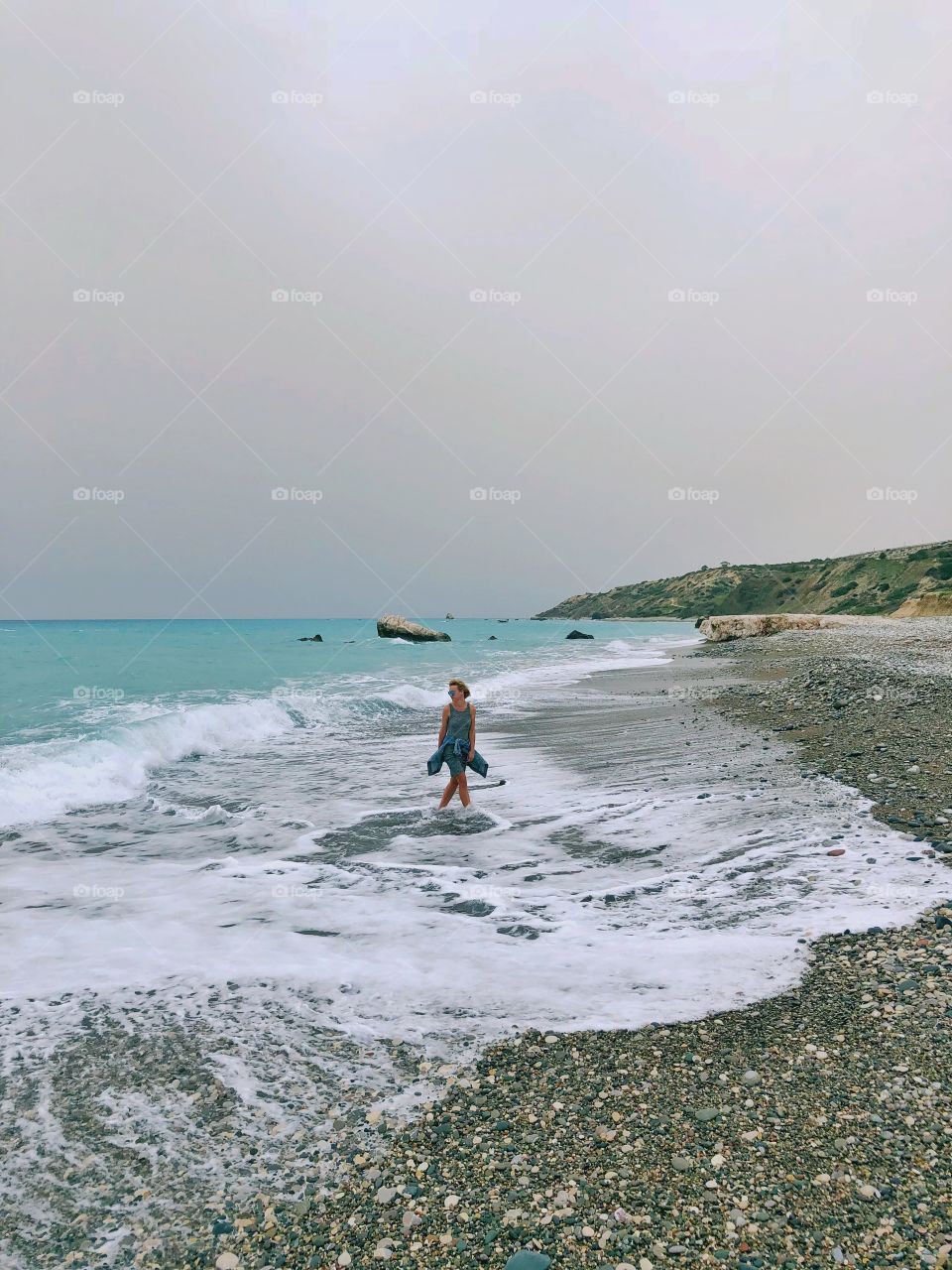 the girl is walking along the beach