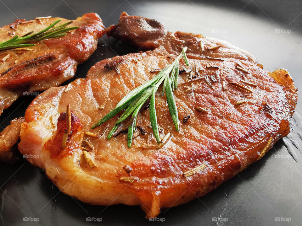 Pan fried pork chops on a black plate. Concept for Keto diet and healthy food.