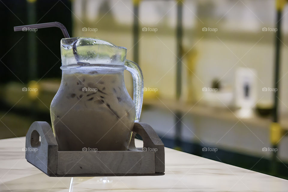 Iced coffee put whipped cream in a glass on the table.