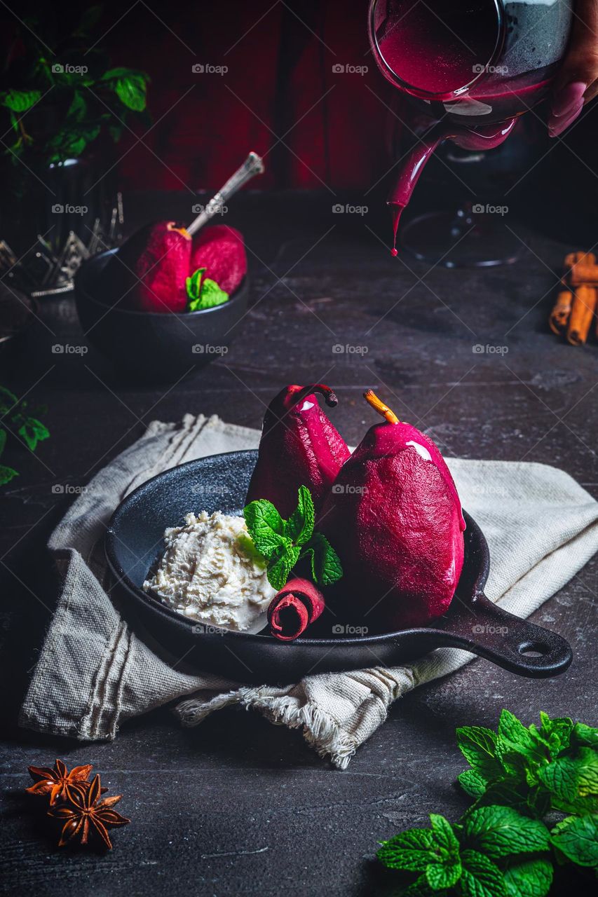 Plate with sweet poached pears in red wine on color background