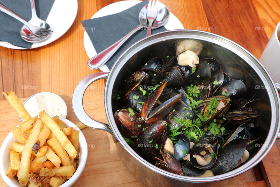 Mussels , fries on top of wooden table