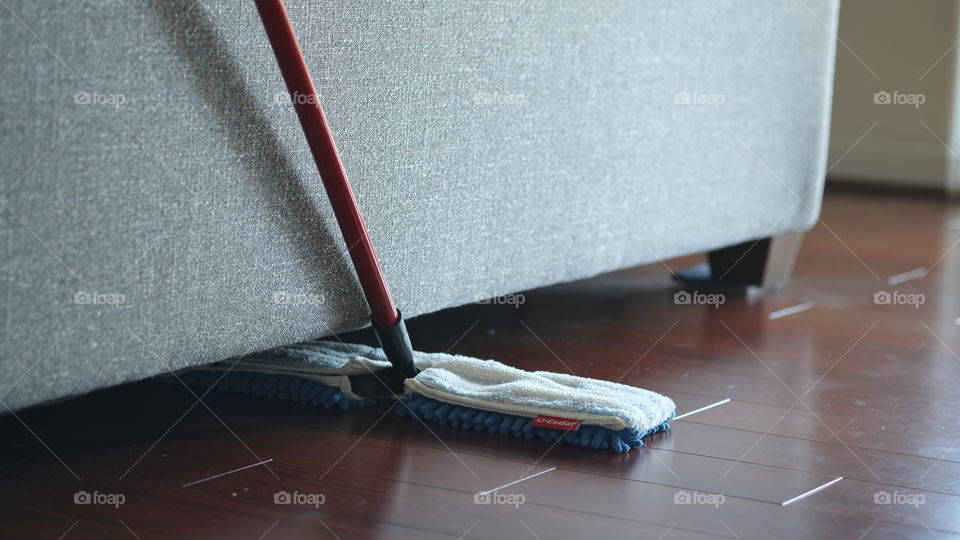 Cleaning under the sofa.