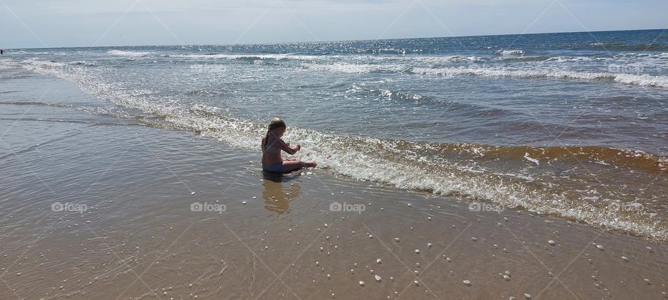 Exploring the ocean. Girl relaxing and playing by the beach.