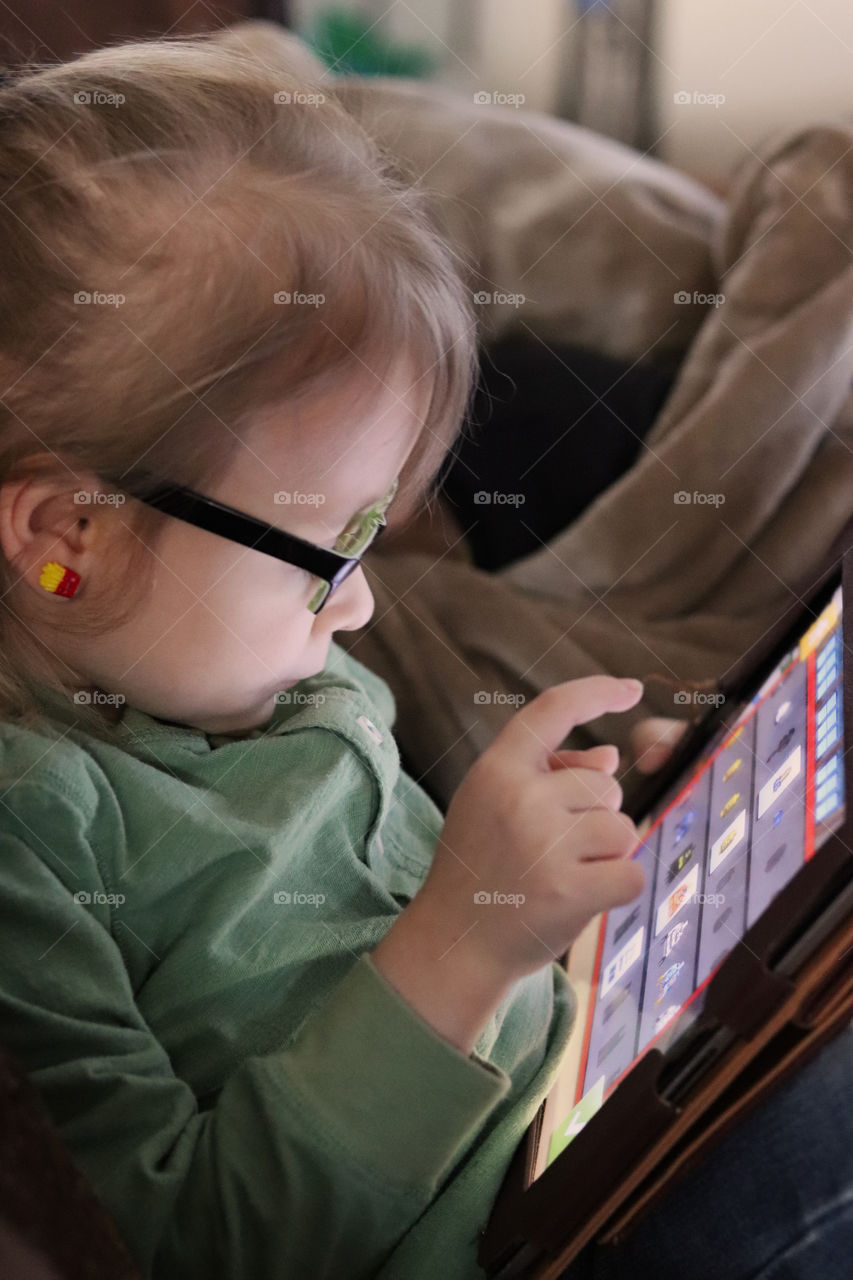 Young child playing a video game on a tablet