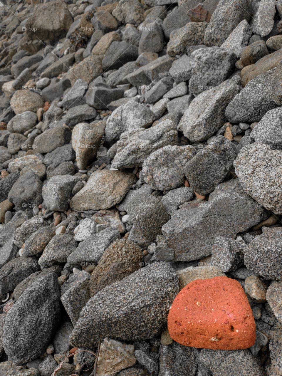 Red rock on a pebble beach.
