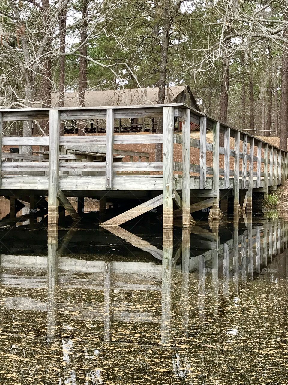 A pier and it’s reflection on a calm lake