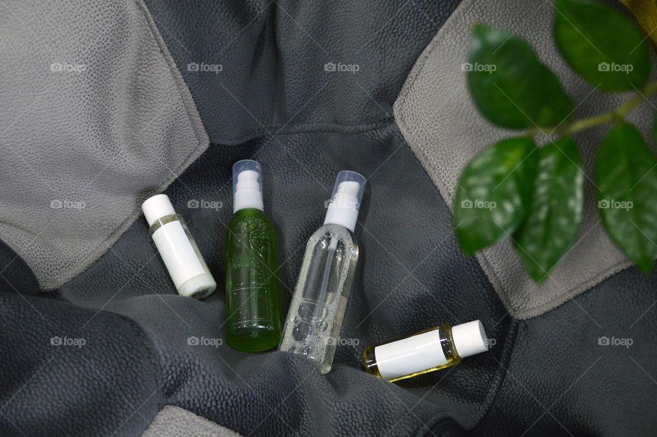 Jars with cream, shampoo and cosmetics on a background with green plants