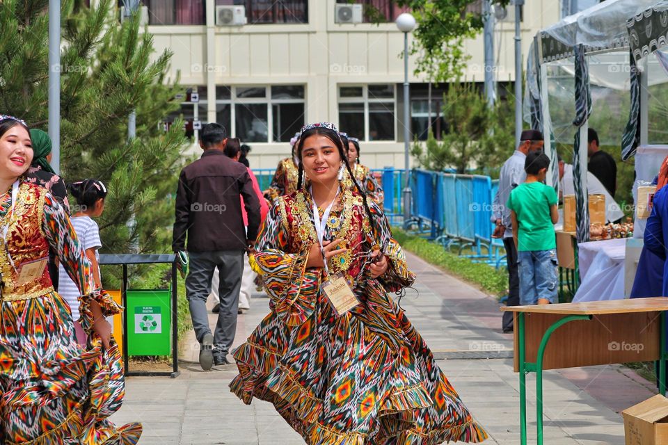 independence day in Uzbekistan. On the day of the holiday, people honor traditions by dressing up in national costumes and organizing fairs with performances. in the photo of a girl in national festive dresses.