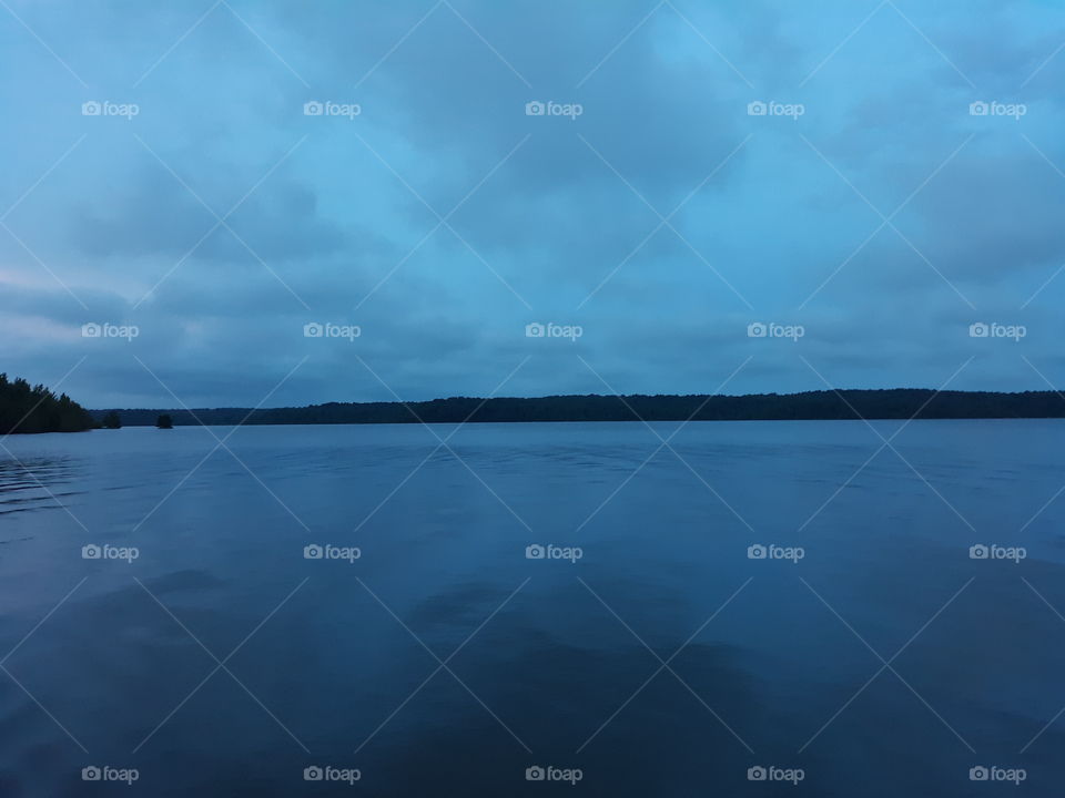 Gray clouds, blue sky, morning on the lake