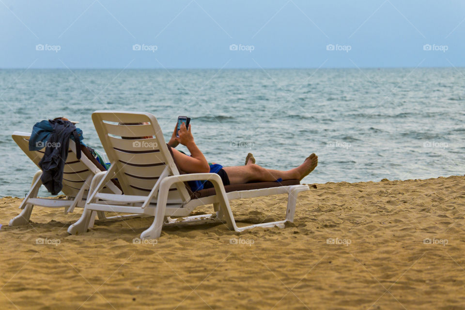 Connected by the beach. tourist using tablet while on vacation