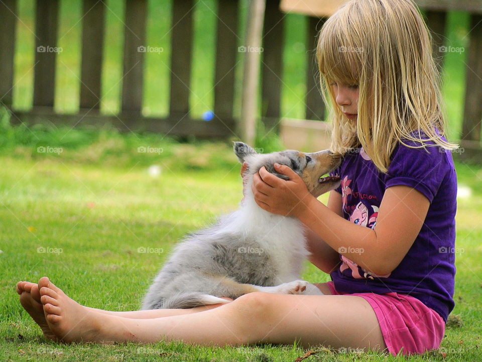 Girl cuddling with a collie pup