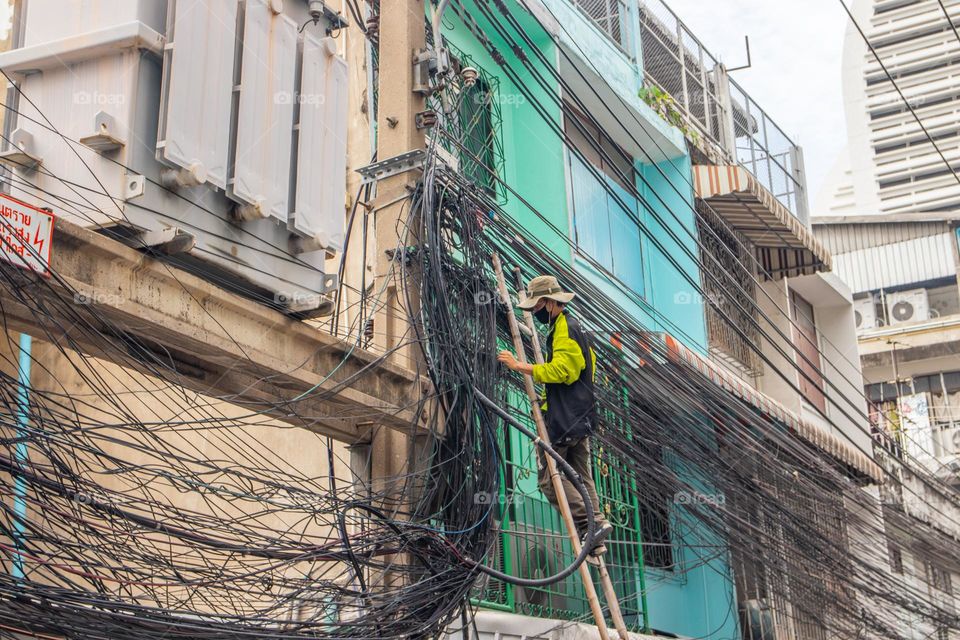 Thai electrician Man by his daily work in the streets of Bangkok Thailand Southeast Asia