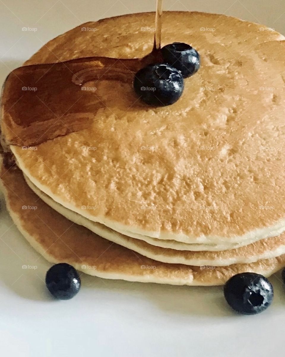 Delicious golden pancakes with blueberries and syrup 