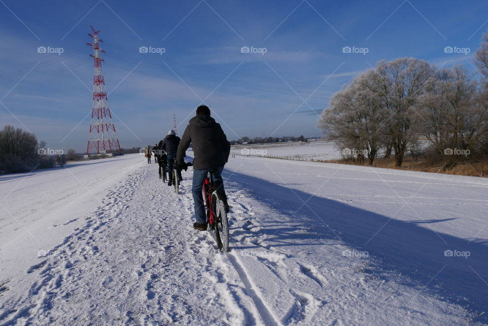 Wintertime biking in the snow with blue sky