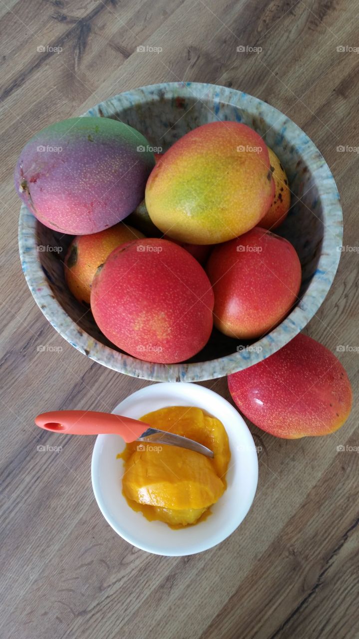 Elevated view of mangoes with pulp in bowl