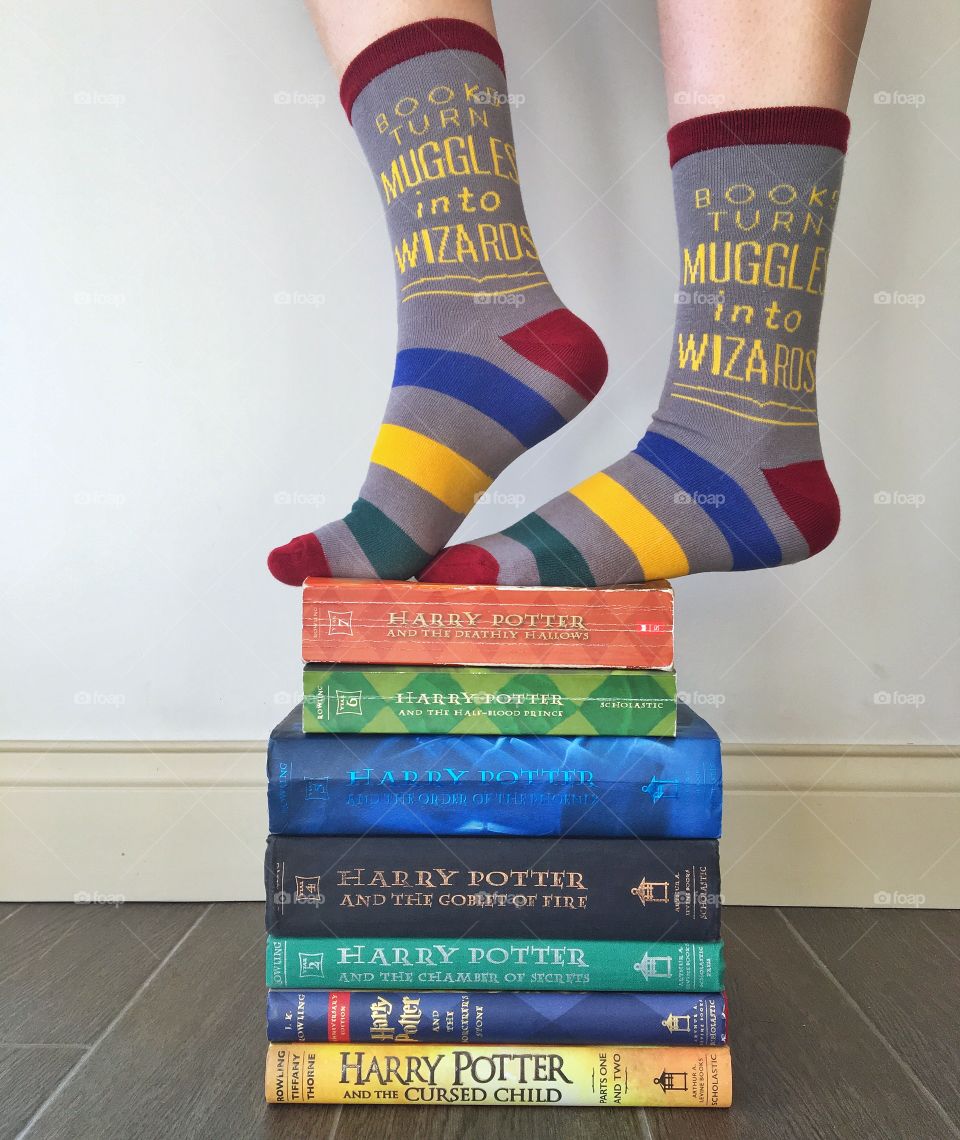 Harry Potter socks standing on a matching book stack. 