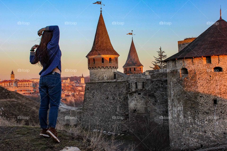 Sunlight. Girl stays near the old castle.