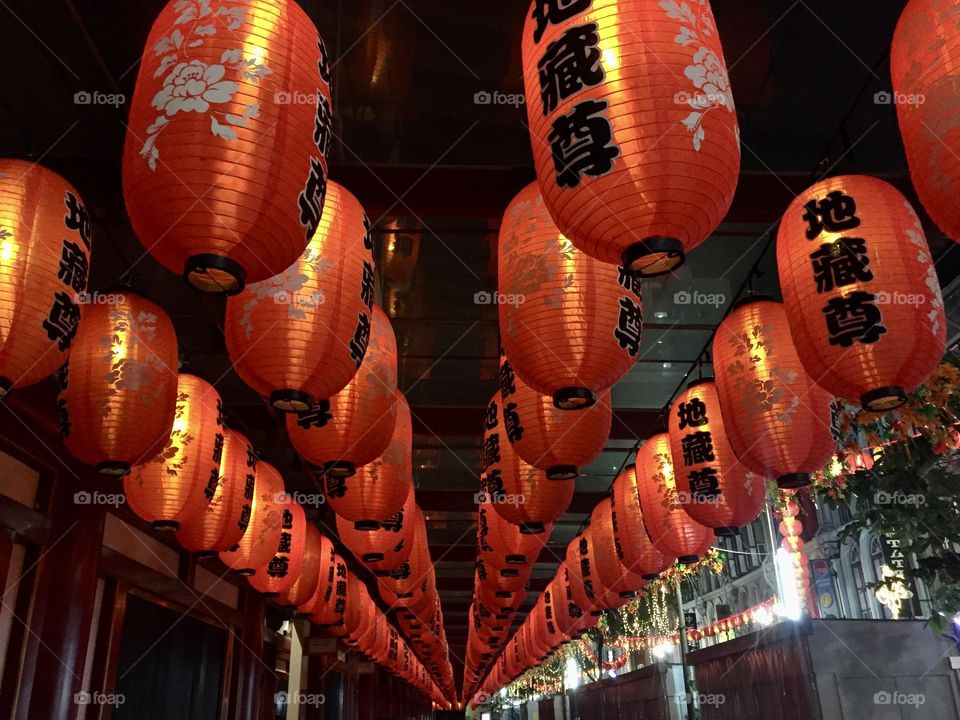 Red paper lanterns with Chinese characters at Buddha tooth relic temple and museum in Singapore by night 