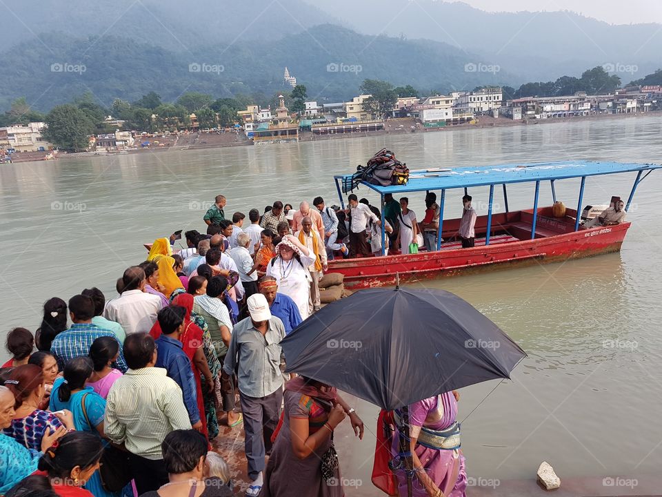 group of people crosing ganga river by boat at rishikesh