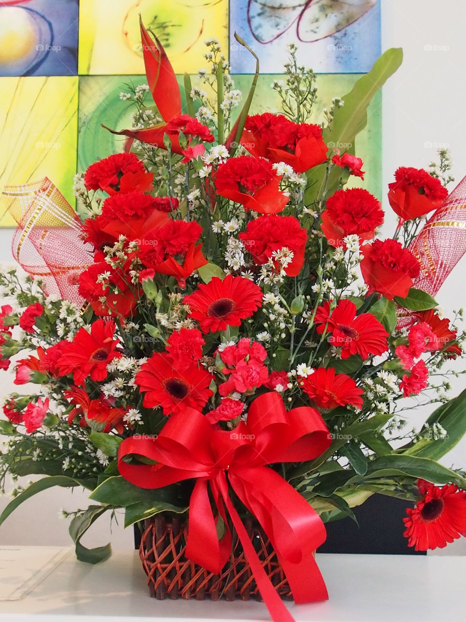 Red flower bouquet in the basket white red bow tie