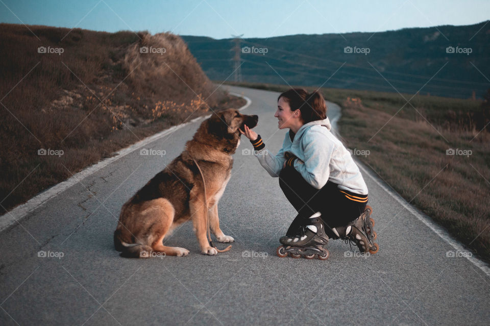 Girl goes out to skate with her dog.