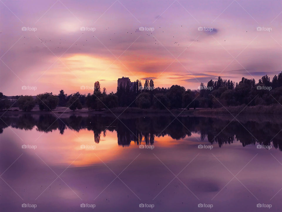 Beautiful symmetrical purple and orange sunset over the lake 