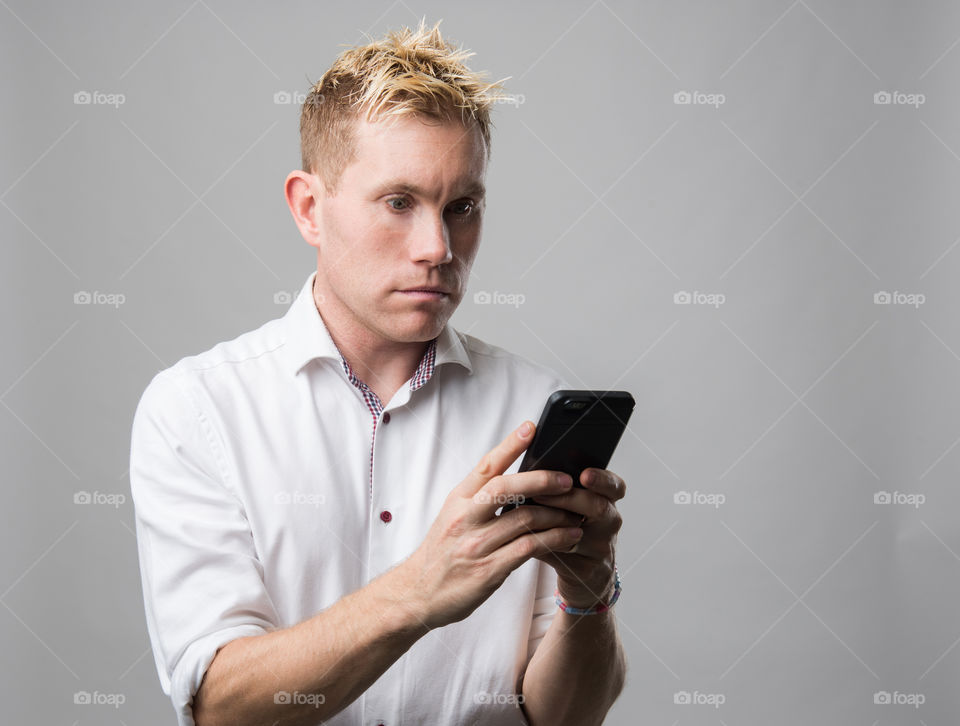 Man scrolling his social media on his cellular phone.