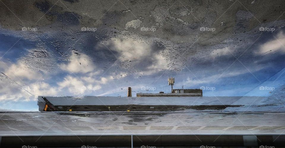 The mirror at the metrostation in a rain puddle looks like there's a ship in the sea