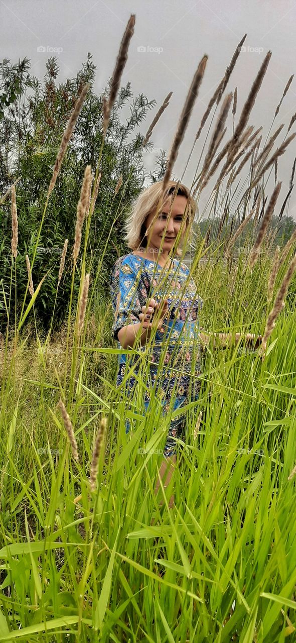девушка идет в высокой траве