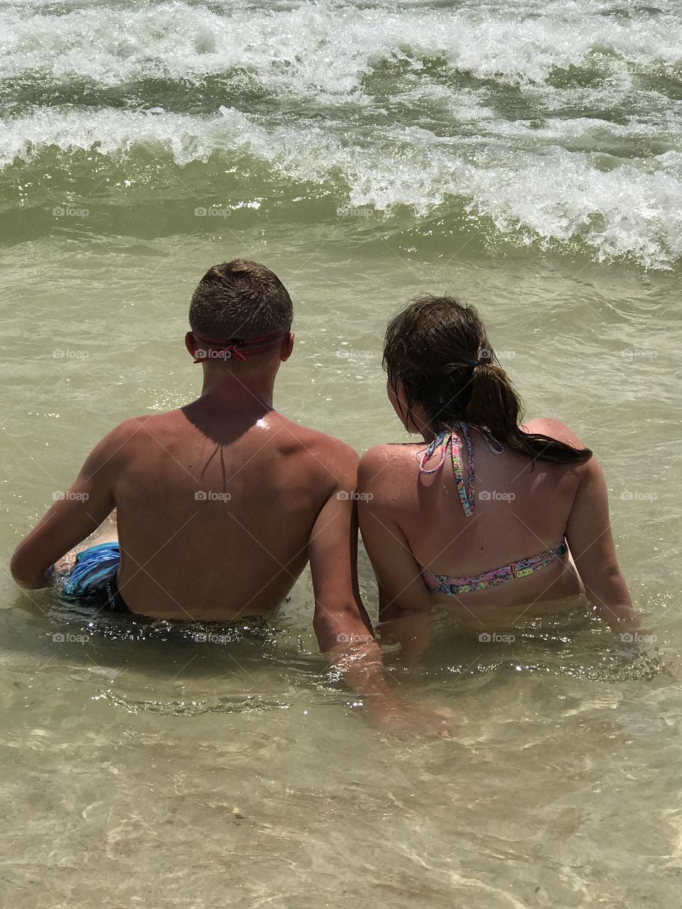 Couple sitting in water at the beach