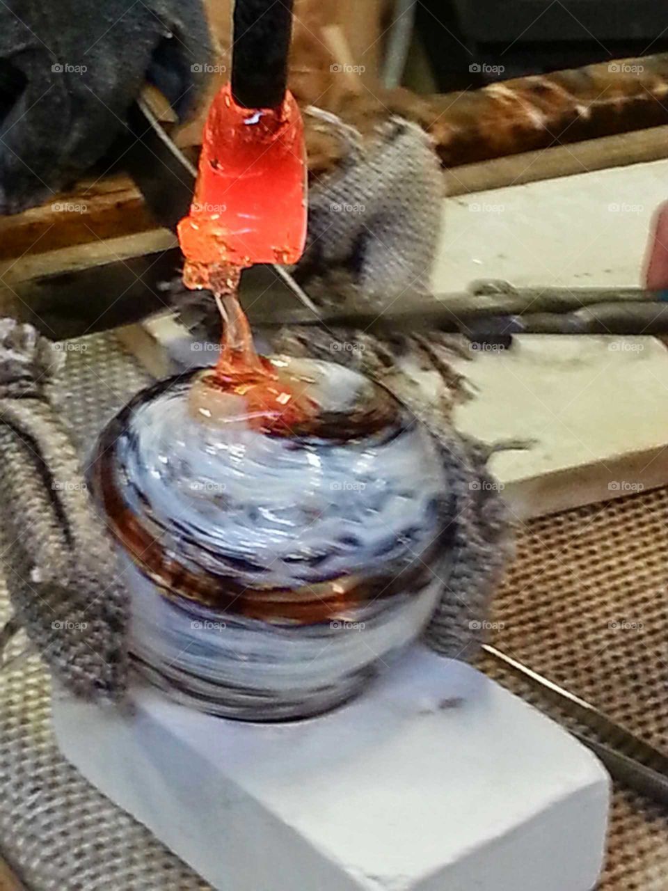 Adding molten glass to a hand blown ornament.