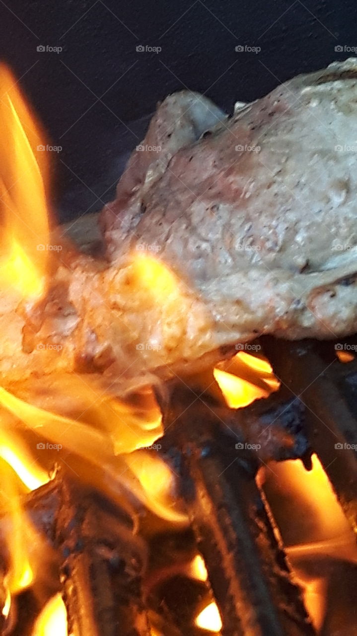 Meat being seared over high flames