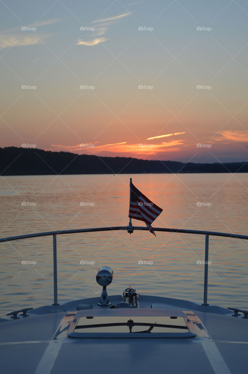 A U.S. flag graces the front of a boat at sunset on the Mississippi River. 