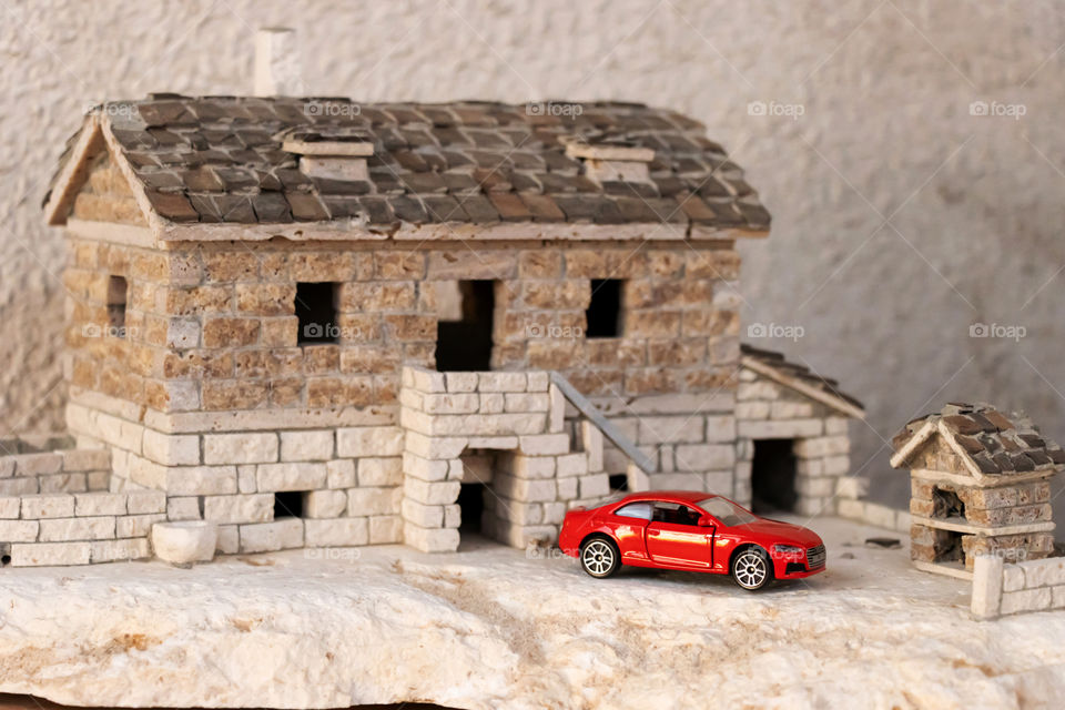 Model of an old dalmatian house and little red toy car