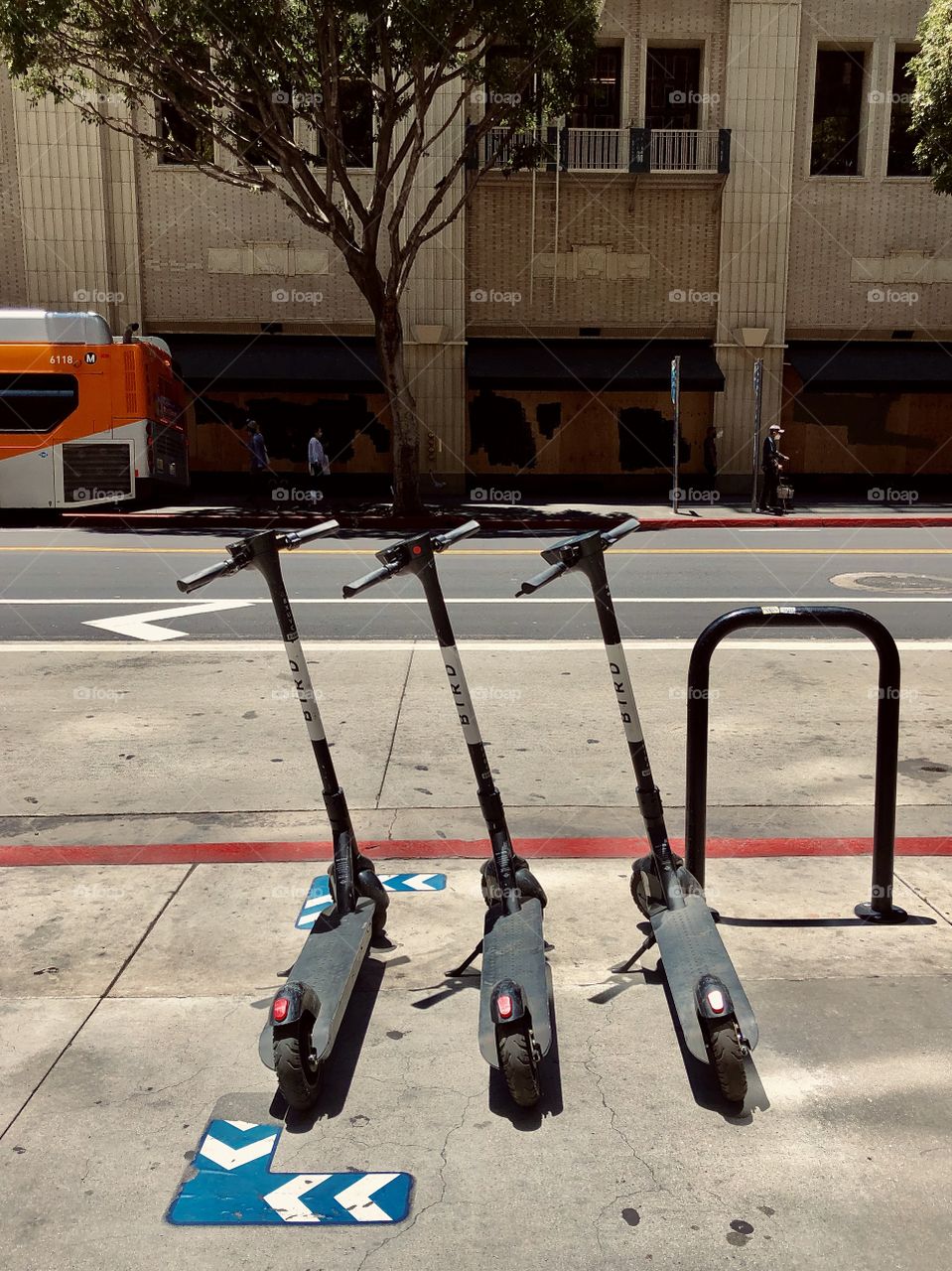 Three electric scooters wait for a rider while parked in a “scooter parking zone” on 7th St in Downtown Los Angeles CA 6.12.2020