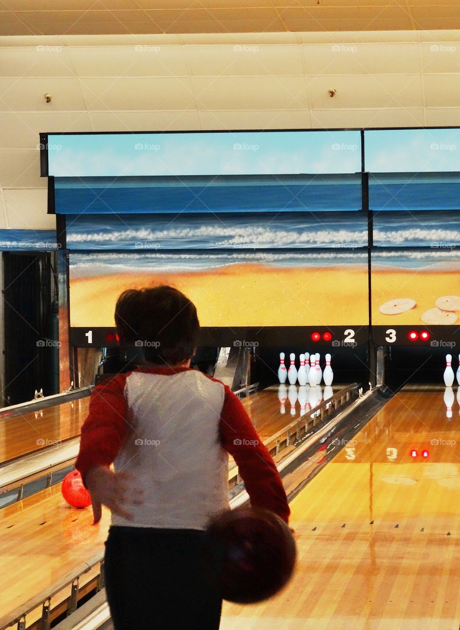 Little Boy At A Bowling Alley. Child On A Bowling Lane
