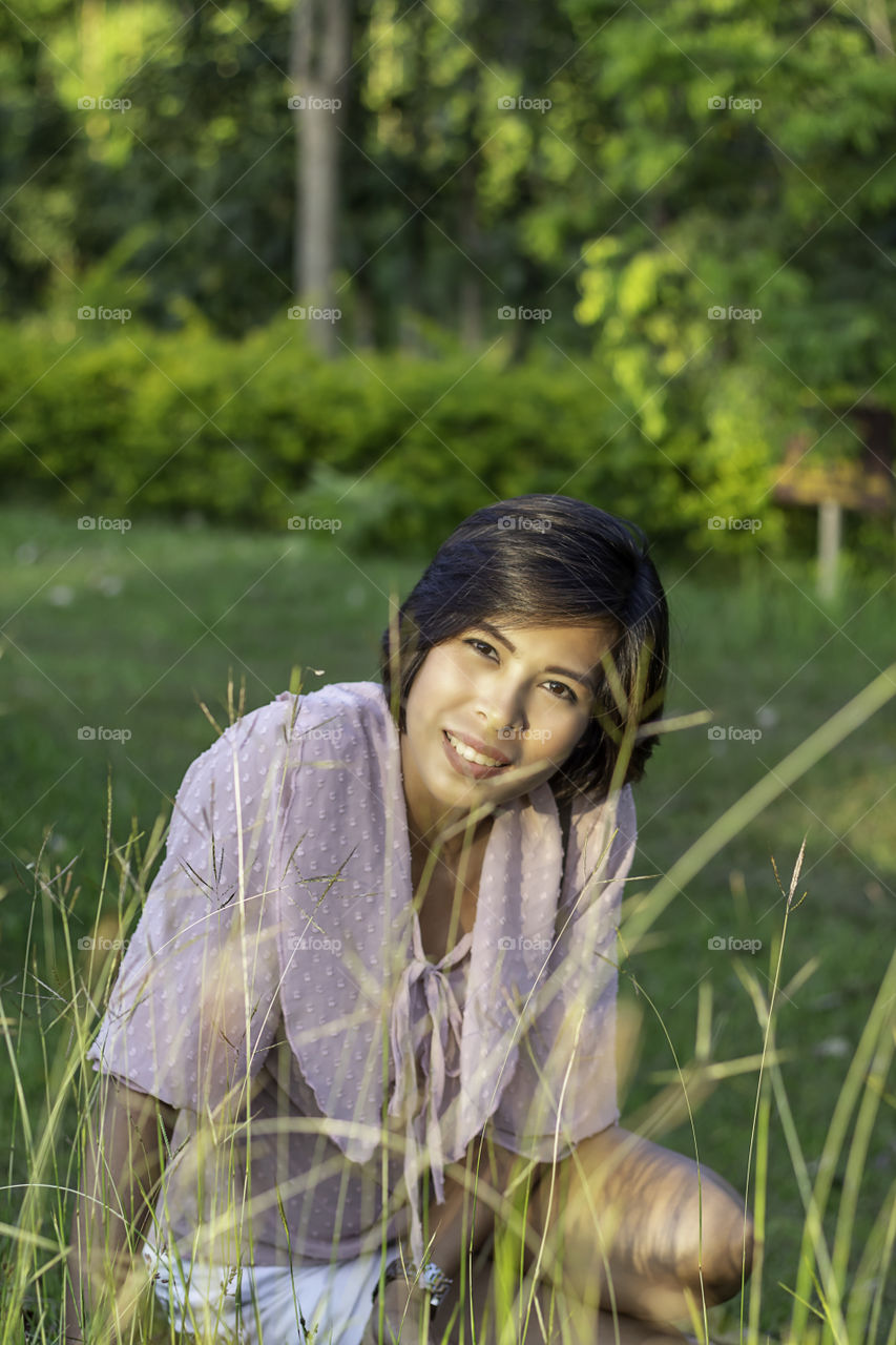 Portrait of Women with short hair brown skin Sitting on the gras