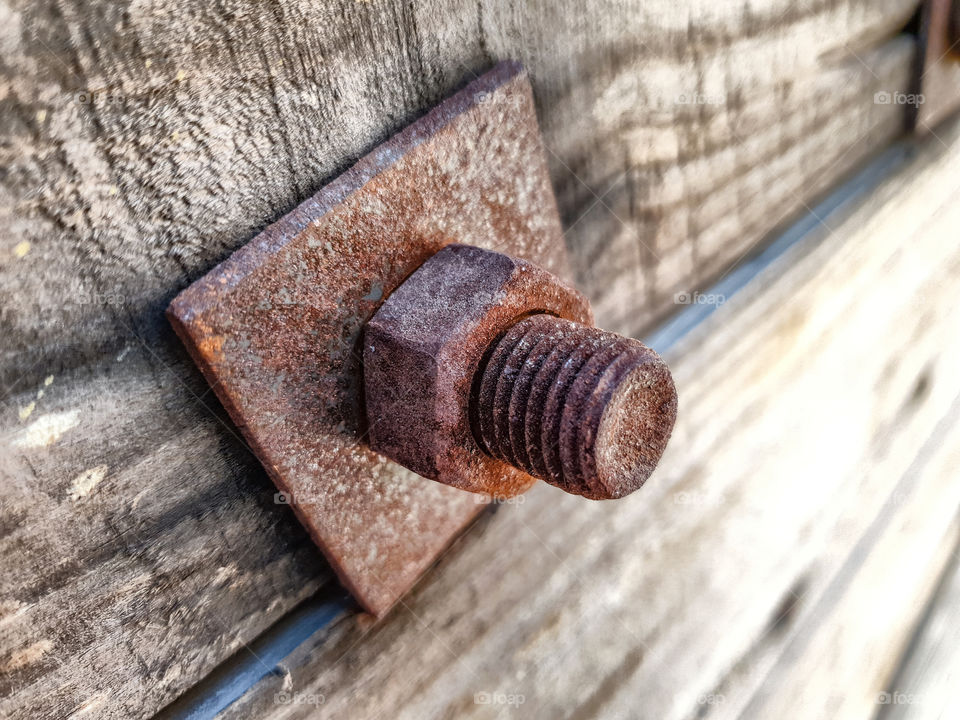 brown rusted bolt and nut on wood